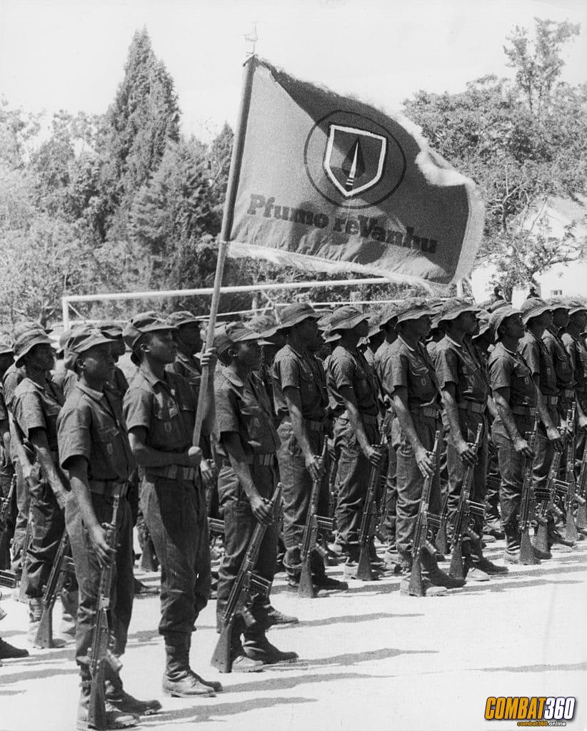 Pfumo re Vanhu 1 New recruits at the Domboshawa Training Depot near Salisbury, Rhodesia, during a passing out parade, 23rd October 1979. They are bearing the flag of the Security Force Auxiliaries (locally known as Pfumo ReVanhu or Spear of the People).