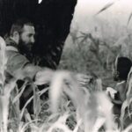 Derek sent his photograph to his Mother in 1982; he is shown in a cornfield in Southern Angola handing an energy bar to local child. Derek and his fellow members of 44 Para had been choppered in from their base in South-West Africa (now Namibia) to carry out anti-insurgent operations.