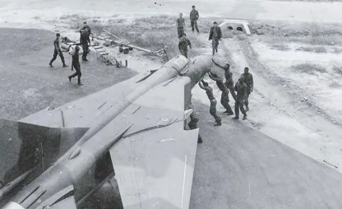 The planform of the MiG-23’s variable geometry wing is clearly displayed as Cuban and Angolan ground crew manoeuvre MiG-23ML C-402 into its revetment